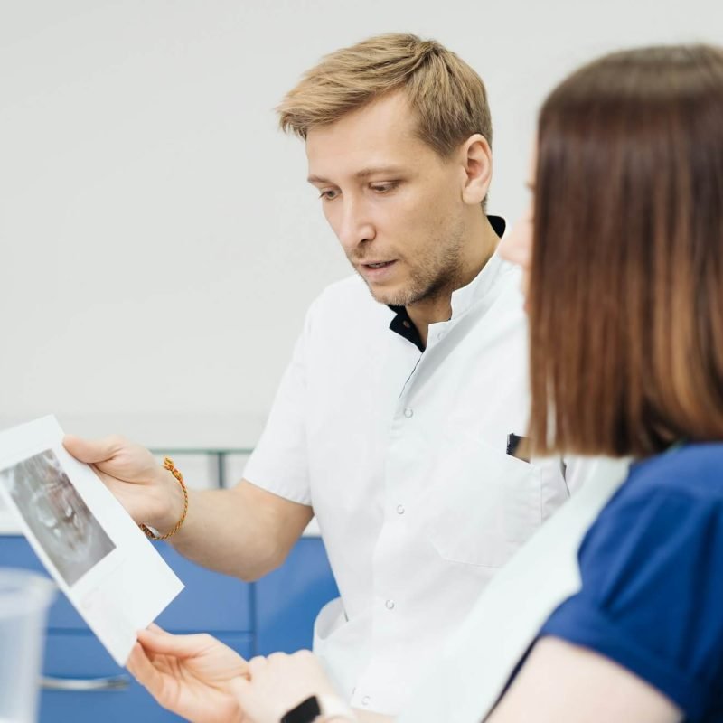 doctor-consulting-his-patient-discussing-tooth-treatment-plan-health-care.jpg